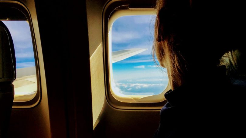 Une personne dans un avion qui regarde par la fenêtre